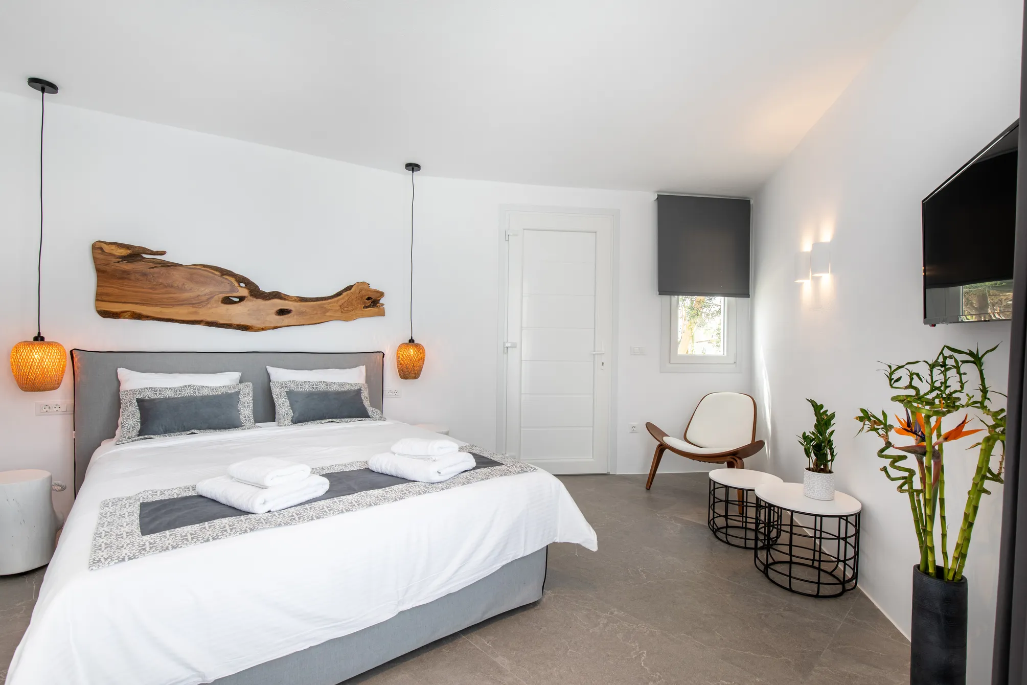 Deluxe Garden Suite with Sea View · Bedroom with driftwood headboard and rattan pendant lamps